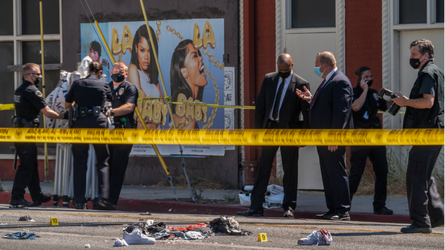 FILE - A photographer with the Los Angeles Police Department, far right, documents the remains of a crime scene in Beverly Hills, Calif., Friday, June 25, 2021.