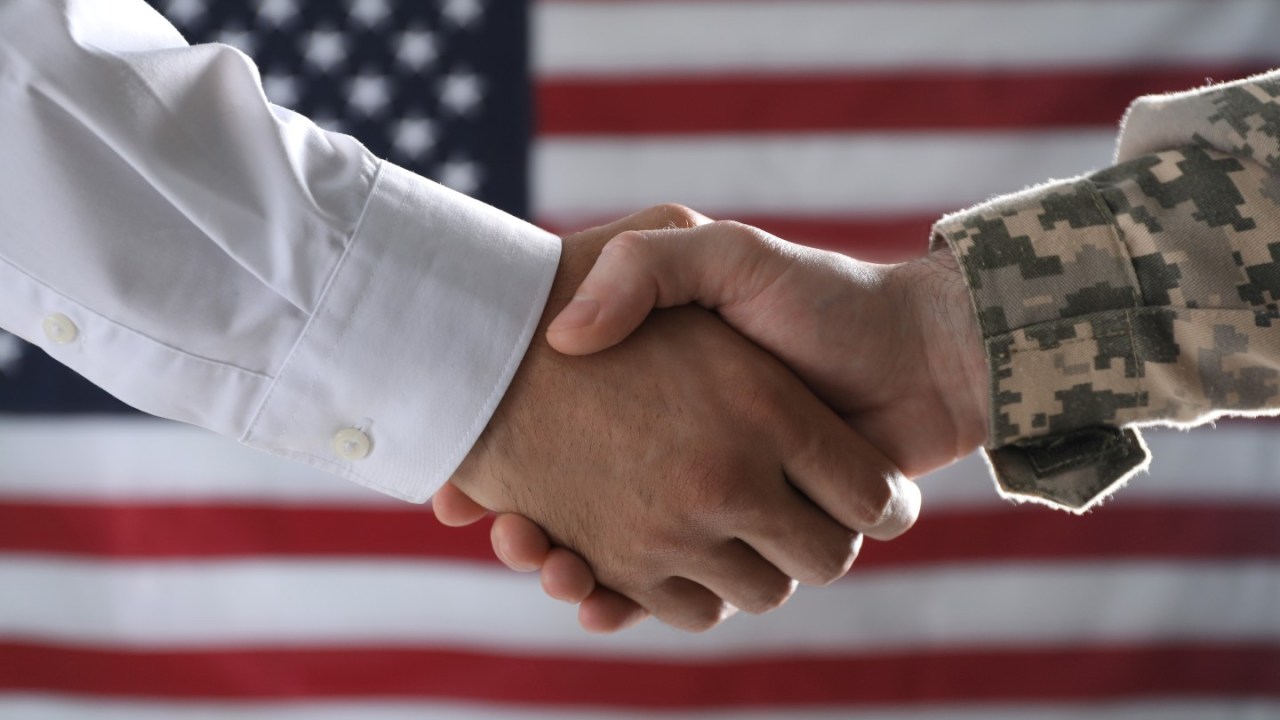 Soldier and businessman shaking hands.