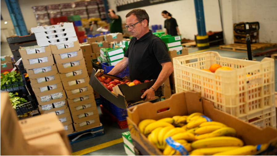 Volunteers sort food to be distributed to charities at a warehouse of the Food Bank Against Hunger in Lisbon, Thursday, Sept. 1, 2022.