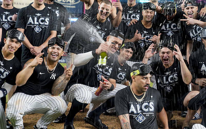 New York Yankees Aaron Judge, center, sprays champagne while celebrating with teammates