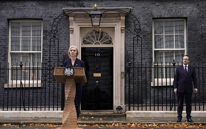 Britain's Prime Minister Liz Truss, center, and husband Hugh O'Leary, far right, leave 10 Downing Street to address the media