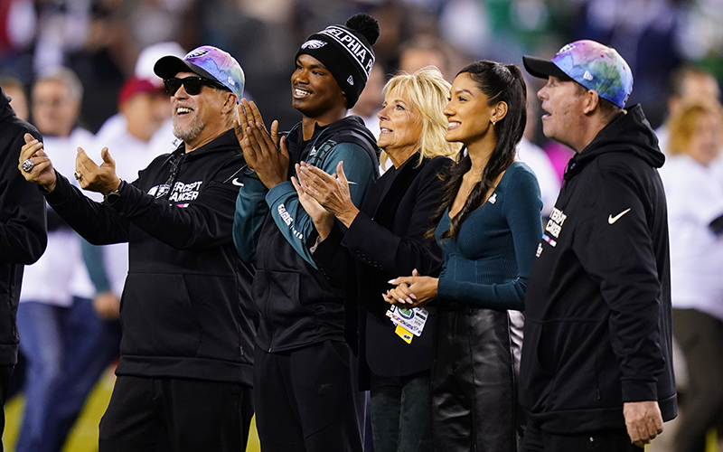 First lady Jill Biden, center, stands on the field with others in Eagles gear