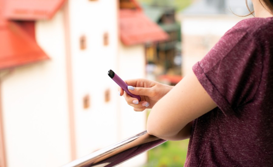 Person vaping an e-cigarette.