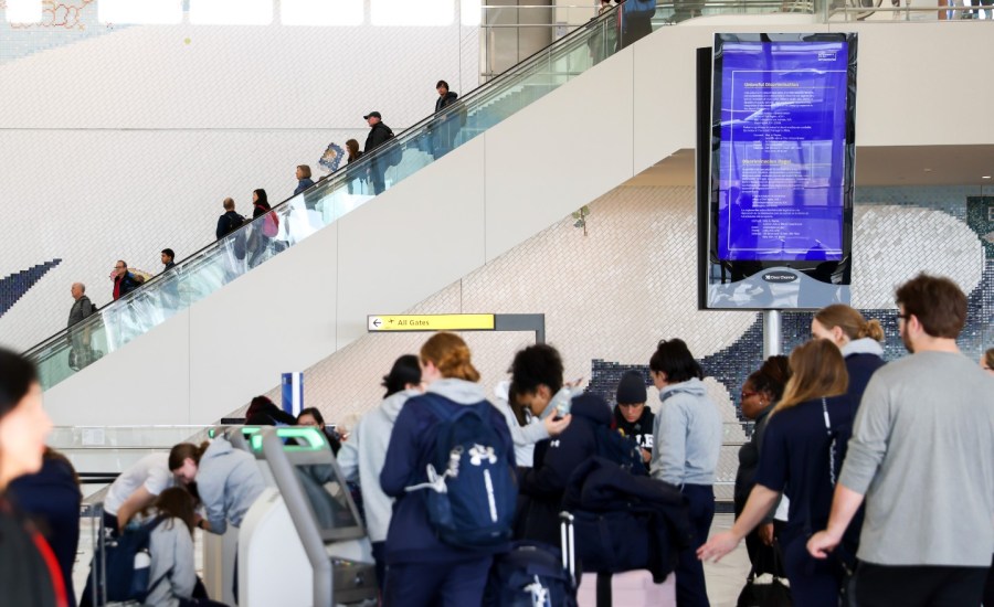 Travelers walk through LaGuardia Airport's Terminal B.