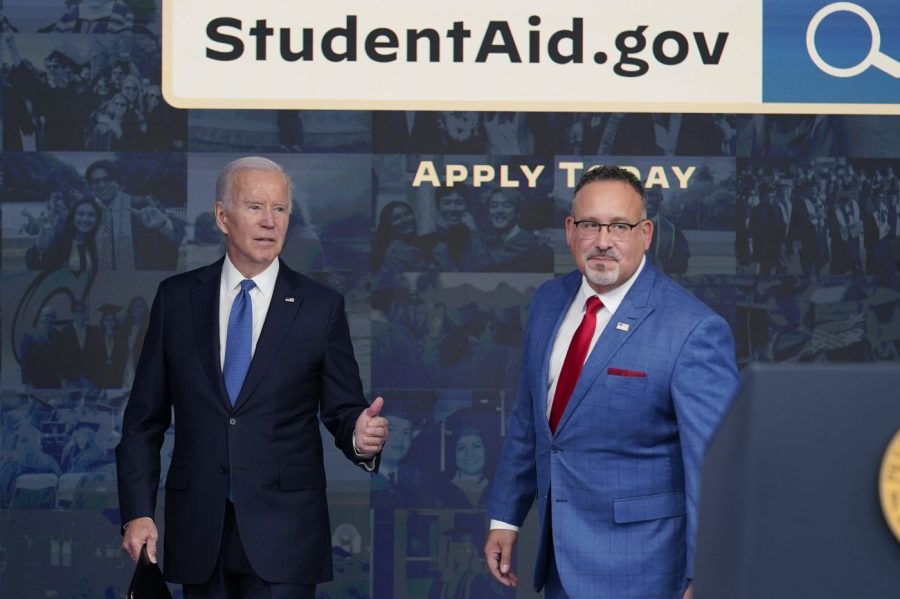 President Biden answers questions with Education Secretary Miguel Cardona as they leave an event