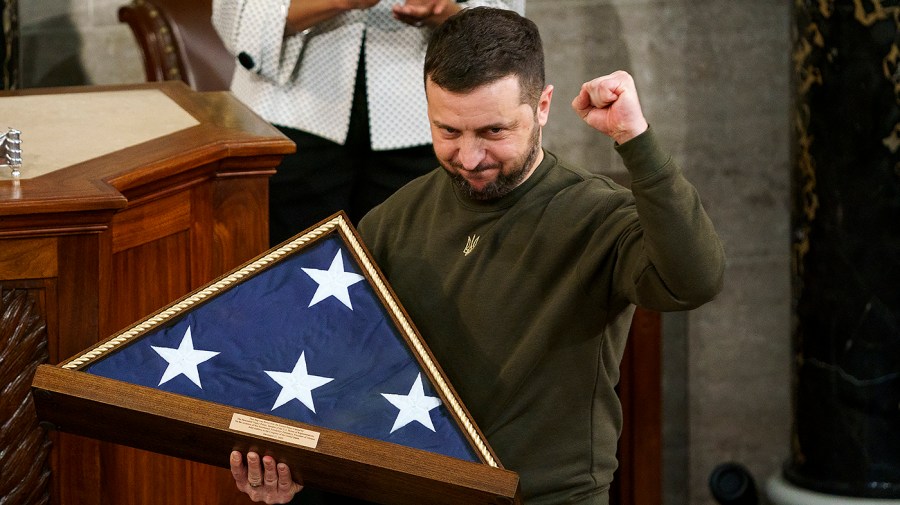 Ukrainian President Volodymyr Zelensky holds an American flag flown at the U.S. Capitol