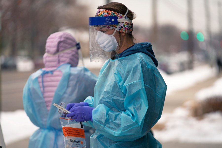 A nurse prepares for a COVID-19 test outside the Salt Lake County Health Department