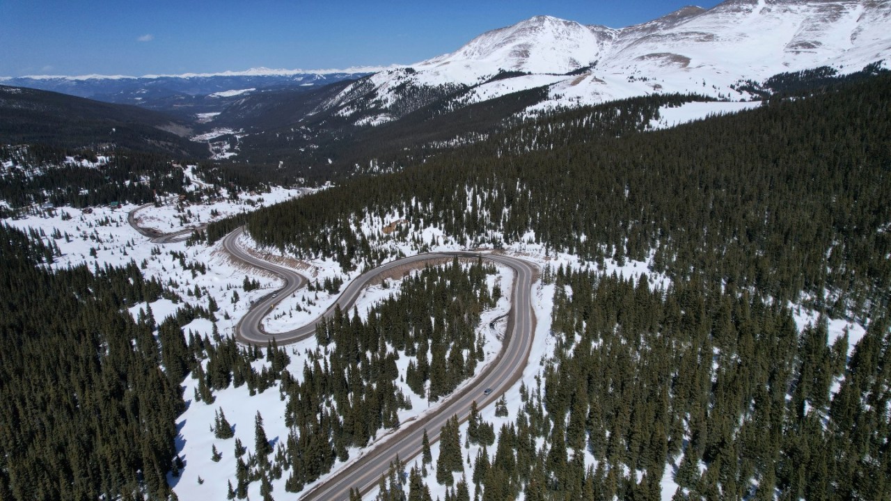 A road winds through the snow-covered Rocky Mountains at Hoosier Pass as seen from the air, Monday, April 18, 2022, near Blue River, Colo.
