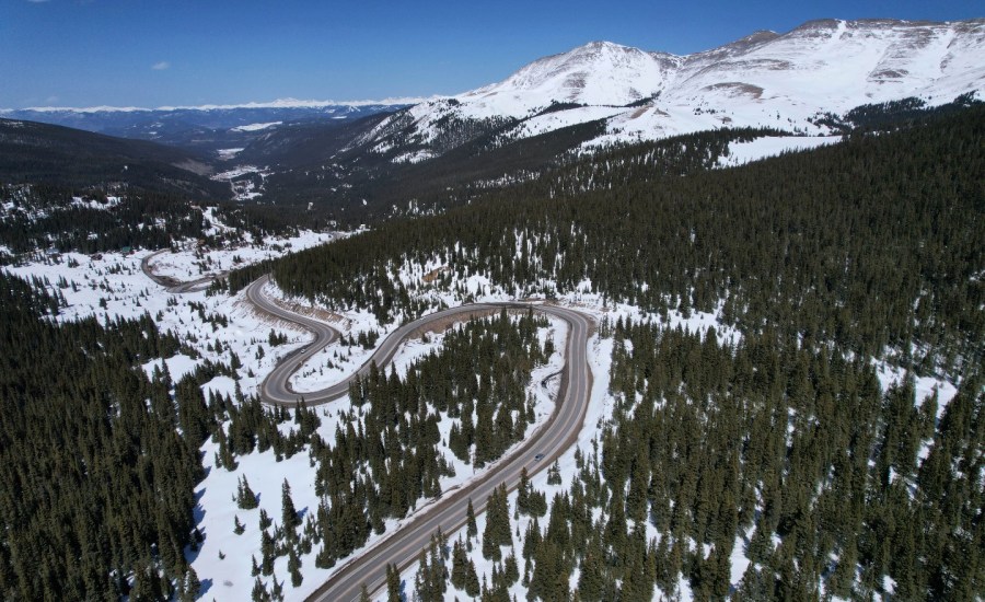 A road winds through the snow-covered Rocky Mountains at Hoosier Pass as seen from the air, Monday, April 18, 2022, near Blue River, Colo.