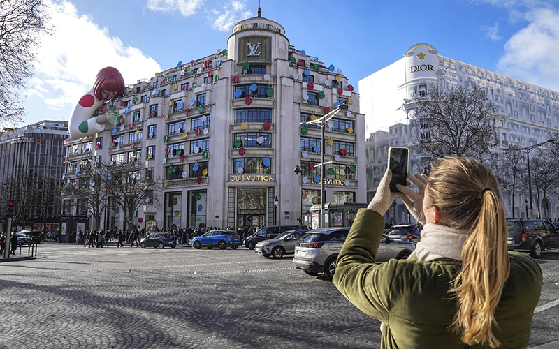 A woman takes a picture from her phone of the installation of Japanese artist Yayoi Kusama