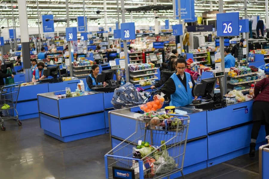 Cashiers process purchases at a Walmart Supercenter