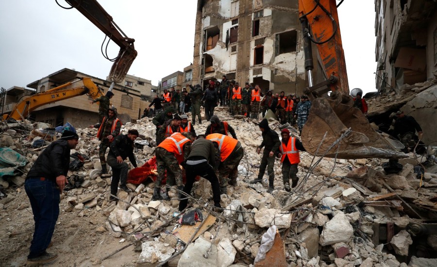 Civil defense workers and security forces search through the wreckage of collapsed buildings in Hama, Syria, Monday, Feb. 6, 2023. A powerful earthquake has caused significant damage in southeast Turkey and Syria and many casualties are feared. Damage was reported across several Turkish provinces, and rescue teams were being sent from around the country. (AP Photo/Omar Sanadiki)