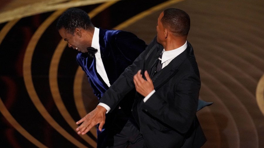 FILE - Will Smith, right, hits presenter Chris Rock on stage while presenting the award for best documentary feature at the Oscars on Sunday, March 27, 2022, at the Dolby Theatre in Los Angeles.