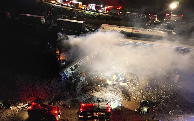 Smoke rises from trains as firefighters and rescuers work after a collision