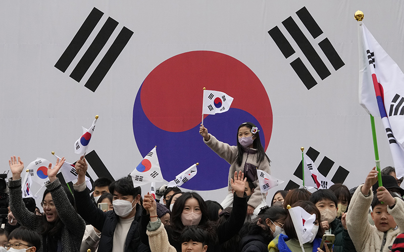 South Koreans wave national flags during a ceremony to celebrate the March First Independence Movement Day