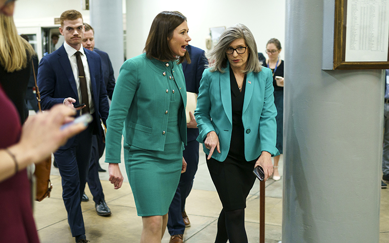 Sens. Katie Britt (R-Ala.) and Joni Ernst (R-Iowa) arrive at the Capitol for votes wearing green