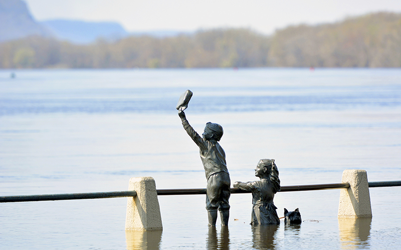 A flooding Mississippi River leaves part of a statue above the water