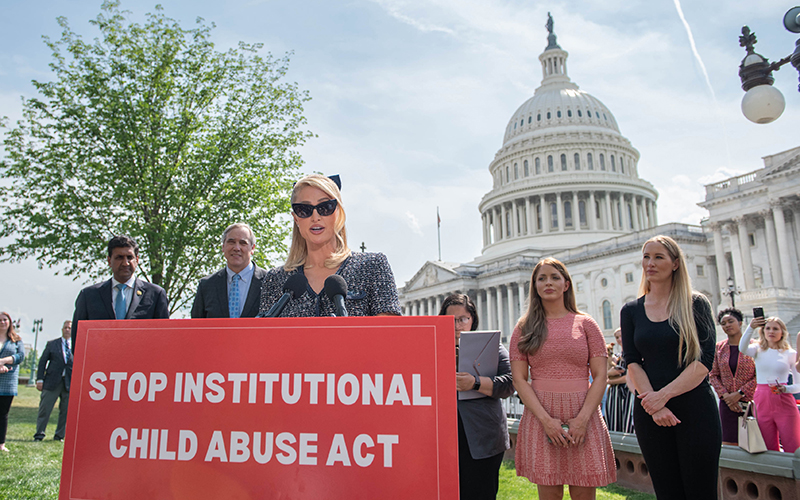 Paris Hilton speaks during a press conference with the Capitol in the background