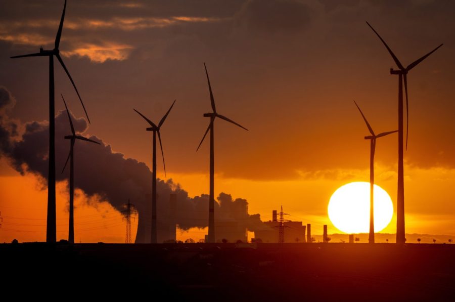 FILE - Steam rises from the coal-fired power plant near wind turbines Niederaussem, Germany, as the sun rises on Wednesday, Nov. 2, 2022. Germany has called for governments around the world to work on setting an ambitious target for renewable energy that would “ring in the end of the fossil fuel age” and help prevent dangerous global warming. (AP Photo/Michael Probst, File)