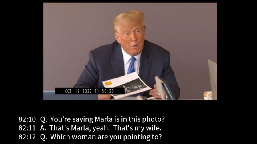 In this image taken from video released by Kaplan Hecker & Fink, former President Donald holds a photograph, presented as evidence during his Oct. 19, 2022 deposition, that shows E. Jean Carroll and her then-husband John Johnson meeting Trump and his wife Ivanka at an event in the 1980s. In his deposition, Trump mistook Carroll as Marla Maples, his now ex-wife, when shown the image. The video recording of Trump being questioned about the rape allegations against him was made public for the first time Friday, May 5, 2023, providing a glimpse of the Republican's emphatic, often colorful denials. (Kaplan Hecker & Fink via AP)