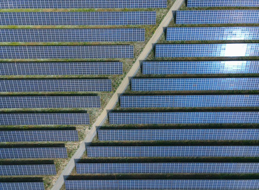 The sun reflected in solar panels of the EnBW solar park at Gottesgabe, Germany, Friday, July 1, 2022. The world is set to add a record amount of renewable electricity capacity this year as governments and consumers seek to offset high energy prices and take advantage of a boom in solar power. (Patrick Pleul/dpa via AP)