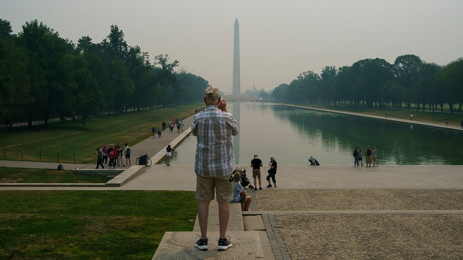 A tourist takes a photo near the Lincoln Memorial in Washington, D.C.