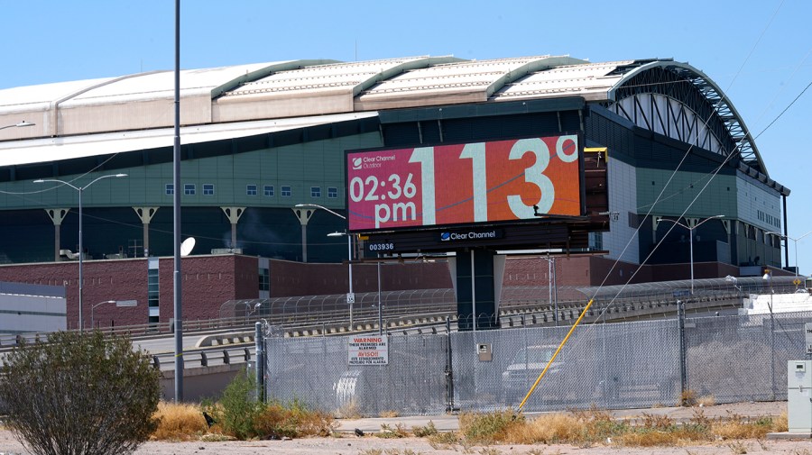 With Chase Field, home of the Arizona Diamondbacks baseball team in the background, a digital billboard updates the time and temperature as temperatures are expected to hit 116-degrees July 18, 2023, in Phoenix.