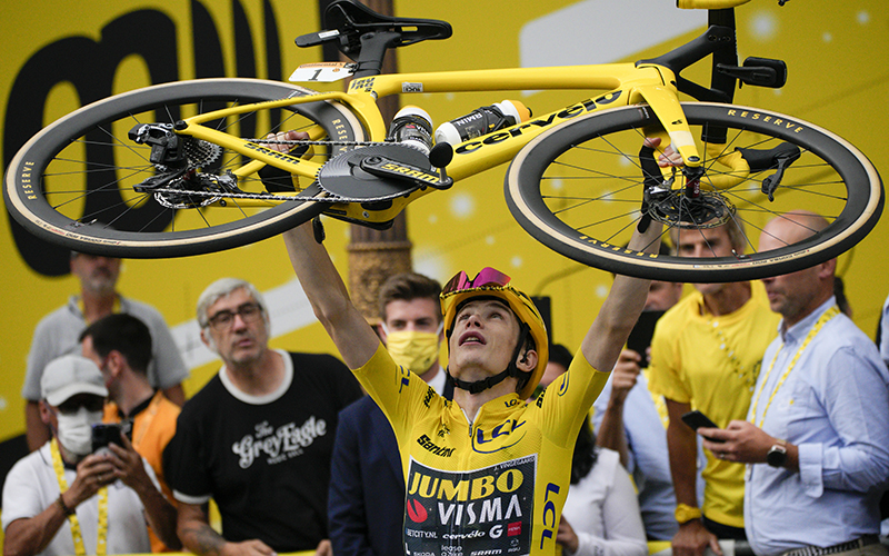 Tour de France winner Denmark's Jonas Vingegaard lifts his bicycle over his head