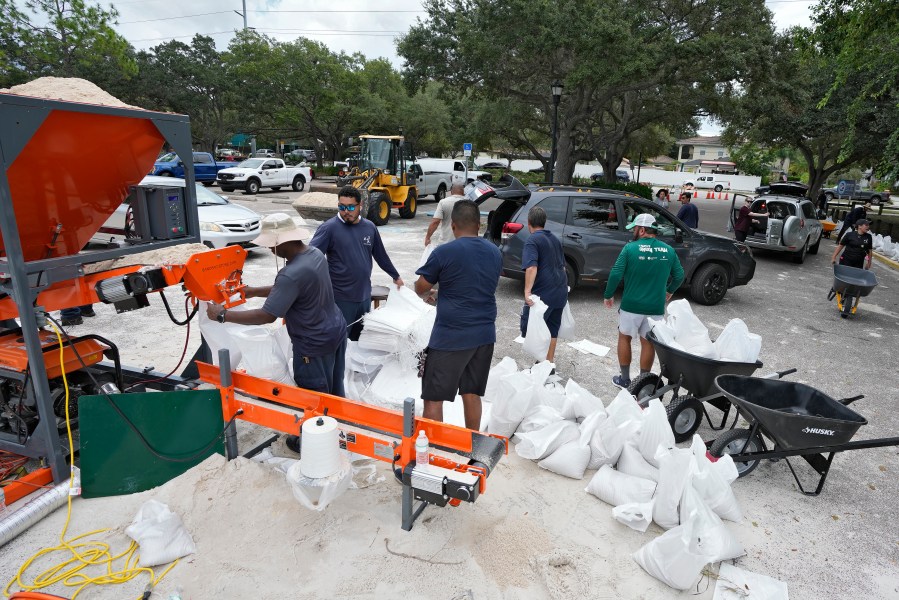 Members of the Tampa, Fla., parks and Recreation Dept., help residents with sandbags Monday, Aug. 28, 2023, in Tampa, Fla. Residents along Florida's gulf coast are making preparations for the effects of Tropical Storm Idalia. (AP Photo/Chris O'Meara)