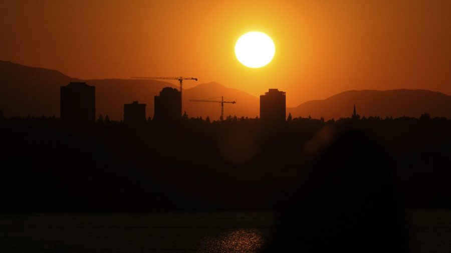 The sun sets over the University District in Seattle, May 13, 2023, seen from 520 Bridge View Park in Medina, Wash.