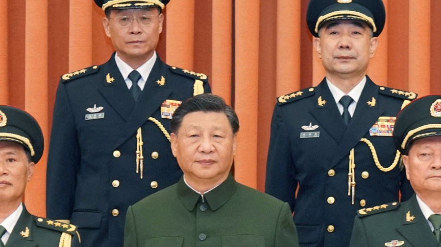 In this photo released by Xinhua News Agency, Chinese President Xi Jinping, also chairman of the Central Military Commission (CMC), center, poses for photos with the new commander of the rocket force Wang Houbin, top left, and its political commissar Xu Xisheng, top right, after promoting them to the rank of general in Beijing on Monday, July 31, 2023. (Li Gang/Xinhua via AP)