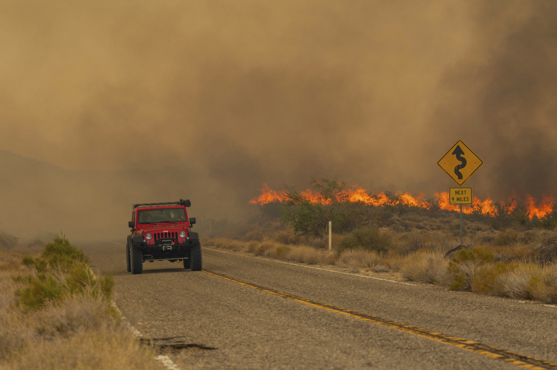 A car passes rising flames