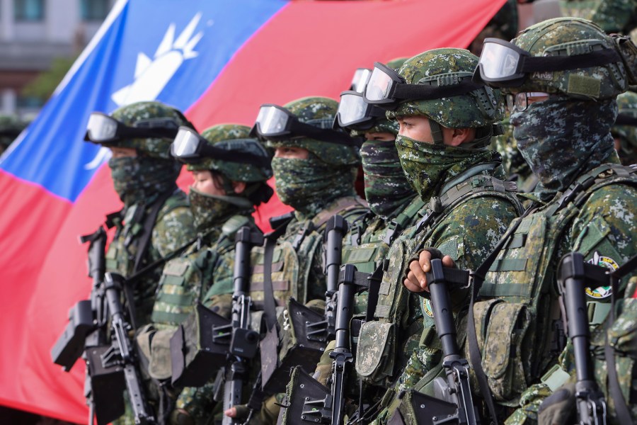 FILE - Soldiers pose for group photos with a Taiwan flag after a preparedness enhancement drill simulating the defense against Beijing's military intrusions, ahead of the Lunar New Year in Kaohsiung City, Taiwan on Jan. 11, 2023. Taiwan says 103 Chinese warplanes flew toward the island in new daily high in recent times. Taiwan's Defense Ministry said that it detected the planes in the 24 hours ending at 6 a.m. Monday, Sept. 18, 2023. (AP Photo/Daniel Ceng, File)