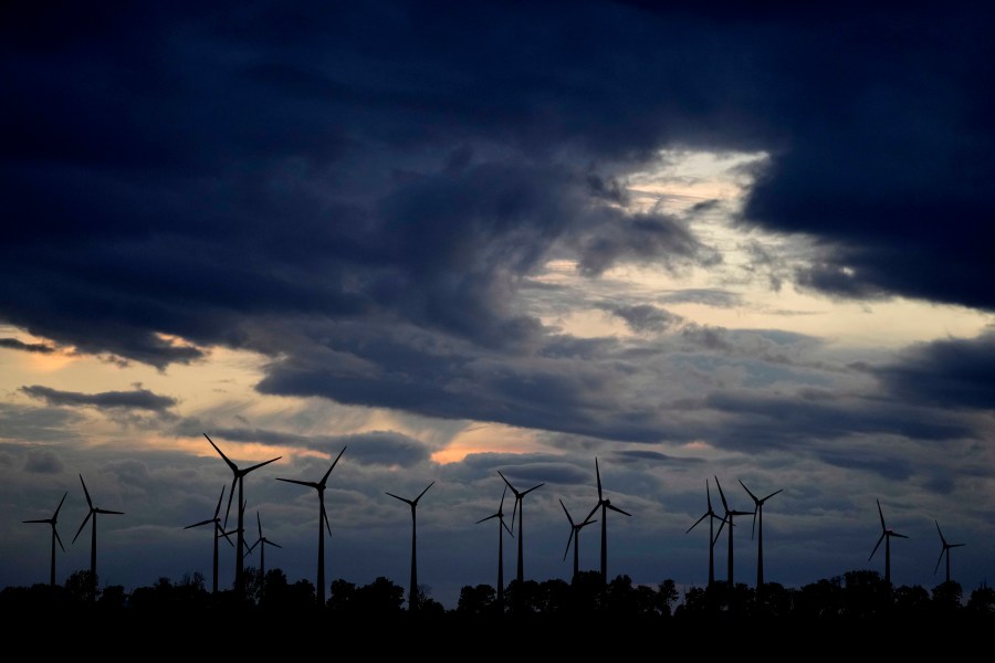 FILE - Wind turbines work at sunset on a wind farm near Aschersleben, Germany, July 23, 2023. Limiting global warming to 1.5 degrees Celsius (2.7 degrees Fahrenheit) is becoming harder but a narrow window remains because clean energy infrastructure has grown around the world, a new report said Tuesday, Sept. 26. (AP Photo/Matthias Schrader, File)