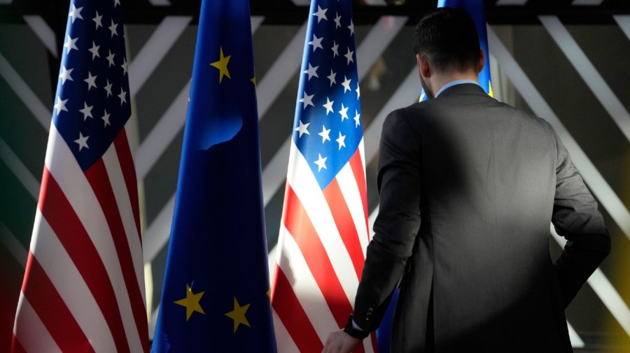 A worker adjusts the US and EU flags prior to the arrival of European Union foreign policy chief Josep Borrell and United States Secretary of State Antony Blinken during the EU-US Energy Council Ministerial meeting at the European Council building in Brussels, on April 4, 2023.