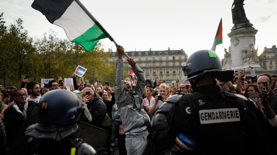 A protestor holds a Palestinian flag during a rally in solidarity with the Palestinian people in Gaza, in Paris, Thursday, Oct. 12, 2023.