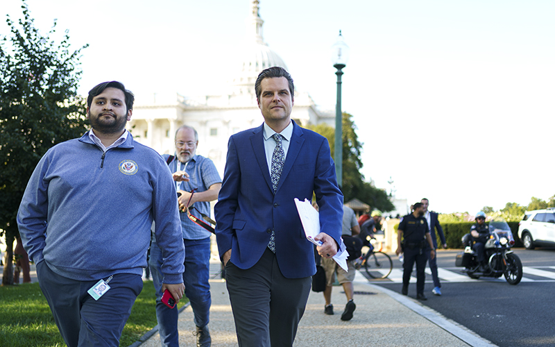 Rep. Matt Gaetz (R-Fla.) heads to the office of Rep. Tim Burchett. He is walking down the sidewalk and the Capitol dome can be seen in the background.