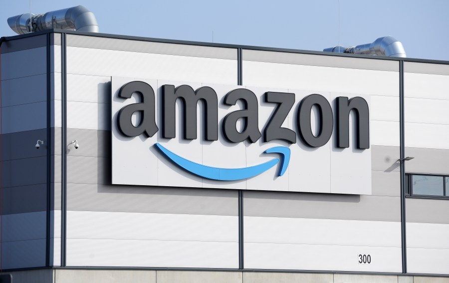 FILE - An Amazon company logo marks the facade of a building, March 18, 2022, in Schoenefeld near Berlin. Amazon is taking another stab toward becoming a regular health care source for customers with the launch of a service centered on virtual care. The e-commerce giant says its Prime customers can now get quick access to a health care provider through a program that costs $9 a month or $99 annually. (AP Photo/Michael Sohn, File)