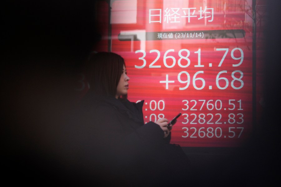 A person walks past an electronic stock board showing Japan's Nikkei 225 index at a securities firm Tuesday, Nov. 14, 2023, in Tokyo. Asian shares were mostly higher Tuesday ahead of potentially market-moving developments, including a U.S.-China summit and data releases from the U.S., Japan and China. (AP Photo/Eugene Hoshiko)