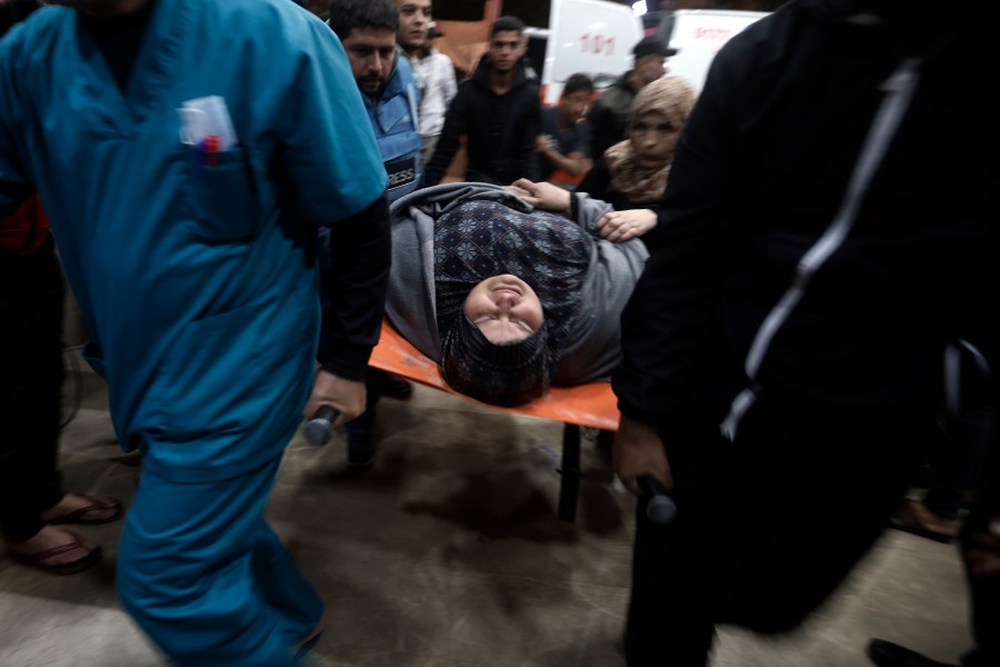 A wounded Palestinian woman is carried into the Nasser Hospital following an Israeli bombardment on Khan Younis refugee camp, southern Gaza Strip, Tuesday, Nov. 21, 2023. (AP Photo/Mohammed Dahman)
