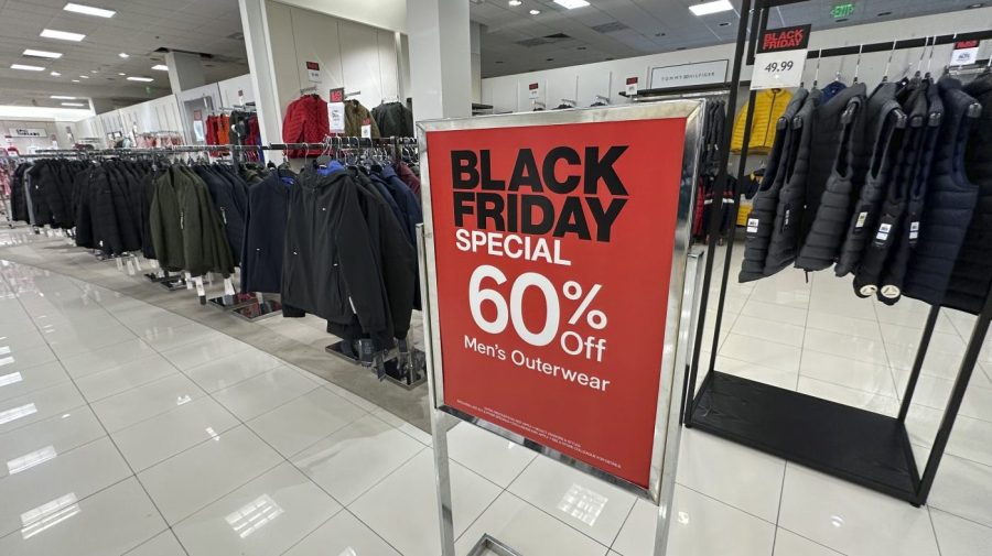 A sign notes Black Friday discount available on racks of men's outerwear in a Macy's department store on Monday, Nov. 20, 2023, in northeast Denver. While Black Friday may no longer look like the crowd-filled, in-person mayhem that it was just decades ago — in large part due to the rising dependence on online shopping that was accelerated by the COVID-19 pandemic — the holiday sales event is still slated to attract millions of consumers. (AP Photo/David Zalubowski)