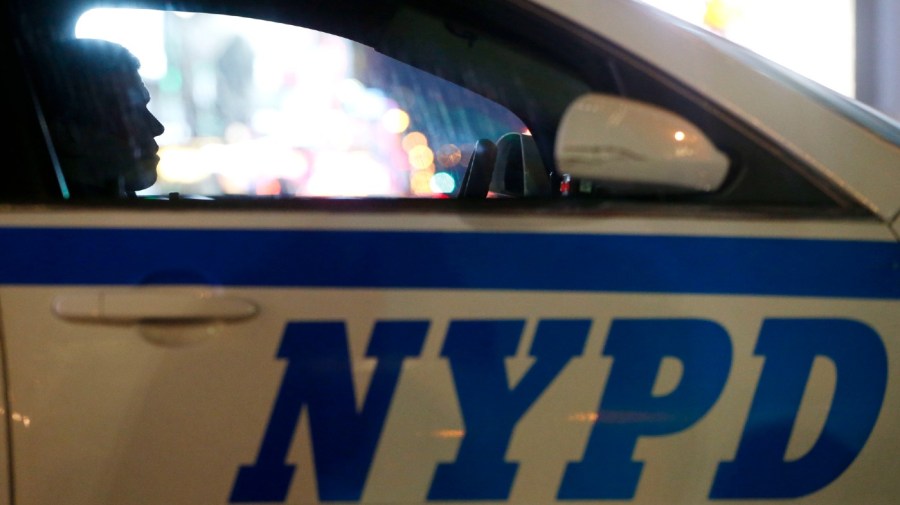 File - A New York City police officer sits in a cruiser at a checkpoint in 2015.