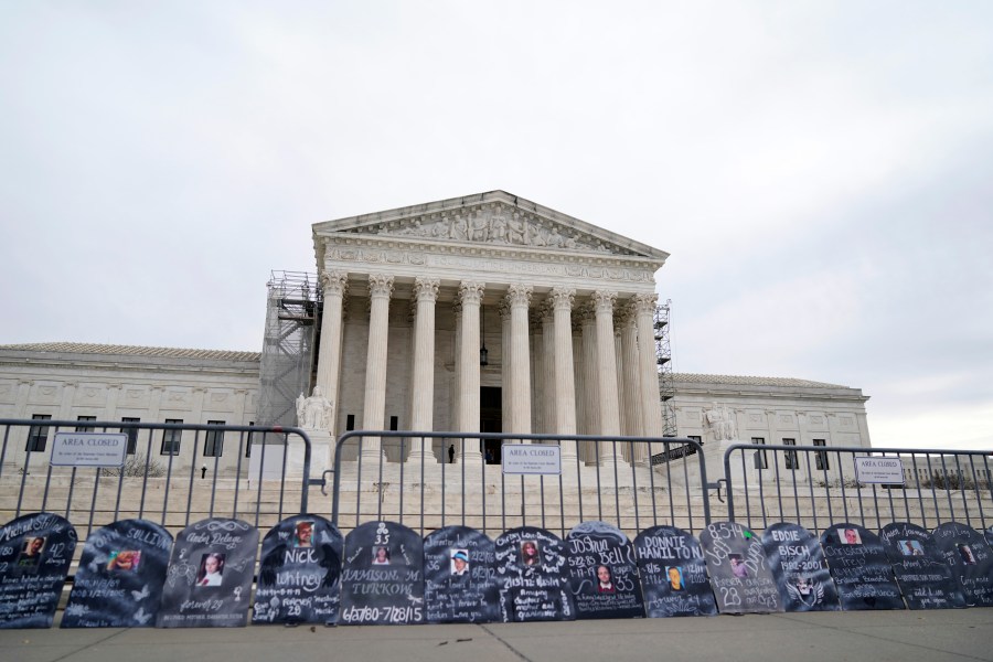 Signs in the shape of grave headstones, with information on people who died from using OxyContin, line a security fence outside the Supreme Court Monday, Dec. 4, 2023, in Washington.The Supreme Court is wrestling with a nationwide settlement with OxyContin maker Purdue Pharma that would shield members of the Sackler family who own the company from civil lawsuits over the toll of opioids. (AP Photo/Stephanie Scarbrough)