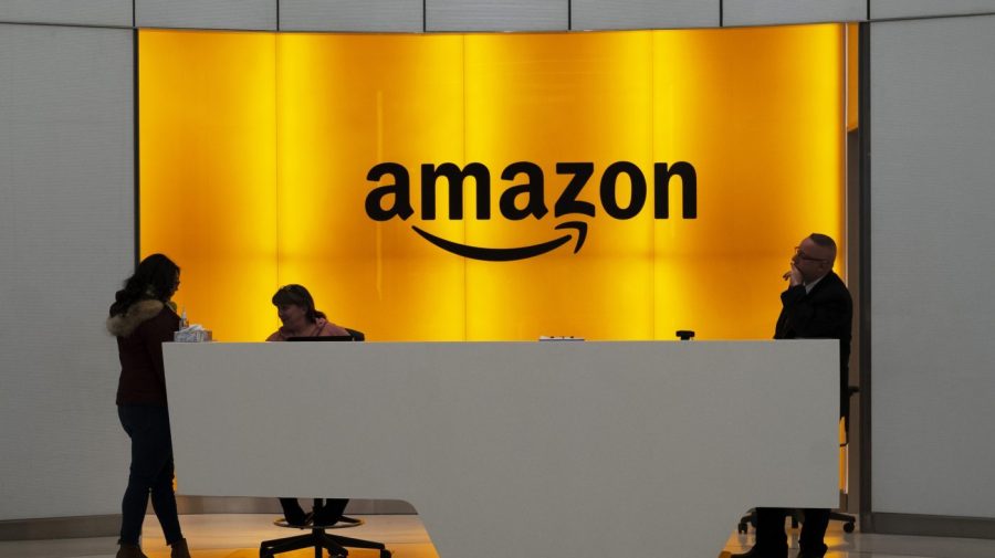 FILE - People stand in the lobby of Amazon offices on Feb. 14, 2019, in New York. Amazon won’t have to pay about 250 million euros ($273 million) in back taxes after European Union judges ruled in favor of the U.S. ecommerce giant, dealing a defeat to the bloc in its efforts to tackle corporate tax avoidance. (AP Photo/Mark Lennihan, File)