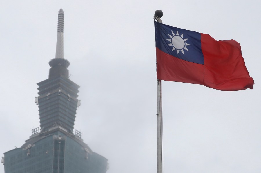 FILE - A Taiwan national flag flutters near the Taipei 101 building at the National Dr. Sun Yat-Sen Memorial Hall in Taipei, Taiwan, on May 7, 2023. Weeks before Taiwan holds elections for its president and legislature, China has renewed its threat to use military force to annex the self-governing island democracy it claims as its own territory. (AP Photo/Chiang Ying-ying, File)