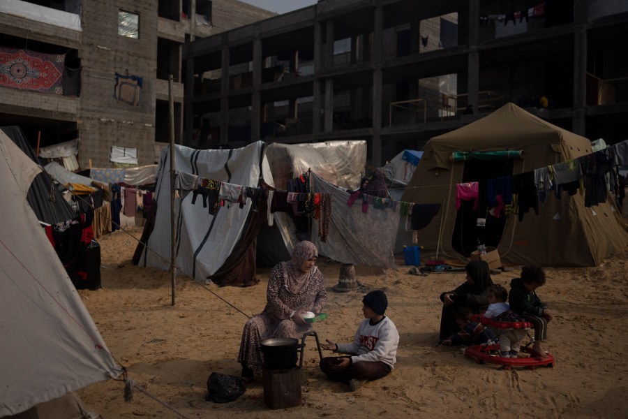 Palestinians displaced by the Israeli bombardment of the Gaza Strip cook at the makeshift tent camp in the Muwasi area on Thursday, Dec. 28, 2023. (AP Photo/Fatima Shbair)