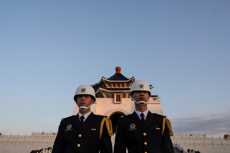 Honor guards take part in a flag lowering ceremony at Chiang Kai Shek Memorial Hall in Taipei, Taiwan on Friday, Jan. 12, 2024 ahead of the presidential election on Saturday. (AP Photo/Louise Delmotte)