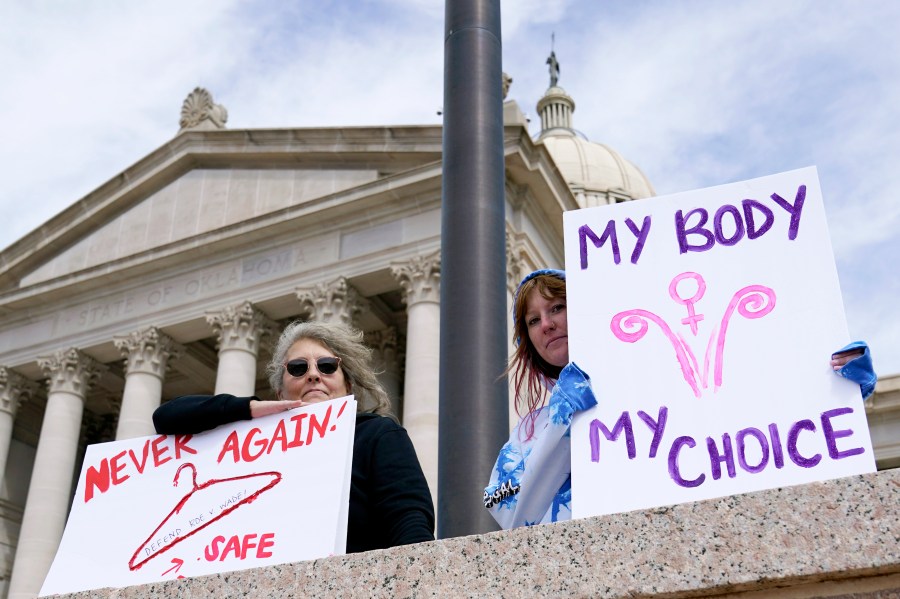 FILE - Dani Thayer, left, and Marina Lanae, right, both of Tulsa, Okla., hold pro-choice signs outside the state Capitol, Wednesday, April 13, 2022, in Oklahoma City. The U.S. Department of Health and Human Services said Friday, Jan 19, 2024, an Oklahoma hospital did not violate federal law when doctors told a woman with a nonviable pregnancy to wait in the parking lot until her condition worsened enough to qualify for an abortion under the state's strict ban. (AP Photo/Sue Ogrocki File)