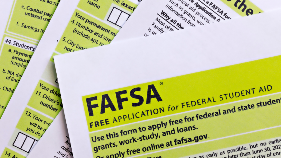 Free Application for Federal Student Aid forms are scattered on a surface.