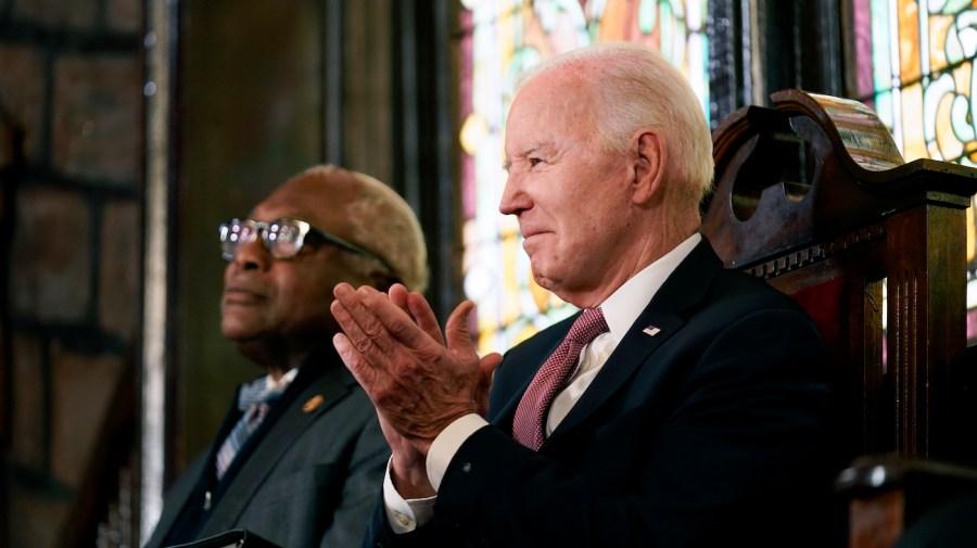 Representative James Clyburn and President Biden sit by each other at an event.